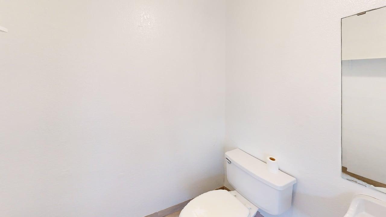 Clean white restroom with mirror and sink