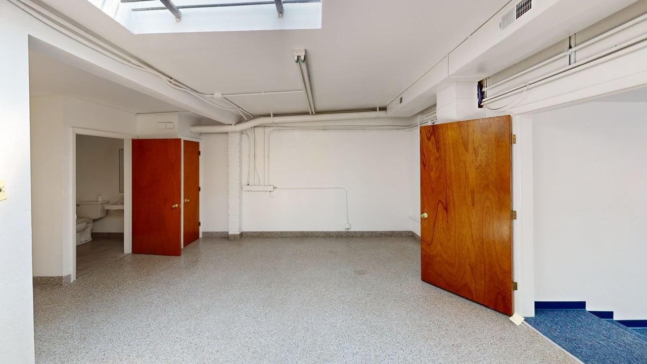 Lower level room with skylight above and restroom nearby